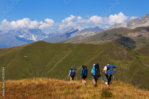 Group of tourists with large backpacks are on mountain