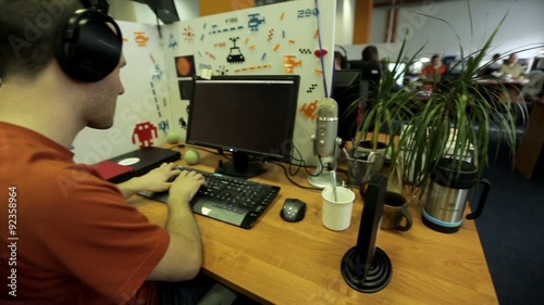 Programmer in headphones sitting at the computer. photo