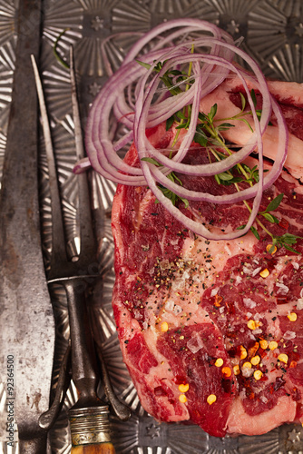 beef steak t-bone with vintage meat fork on metal backdrop photo