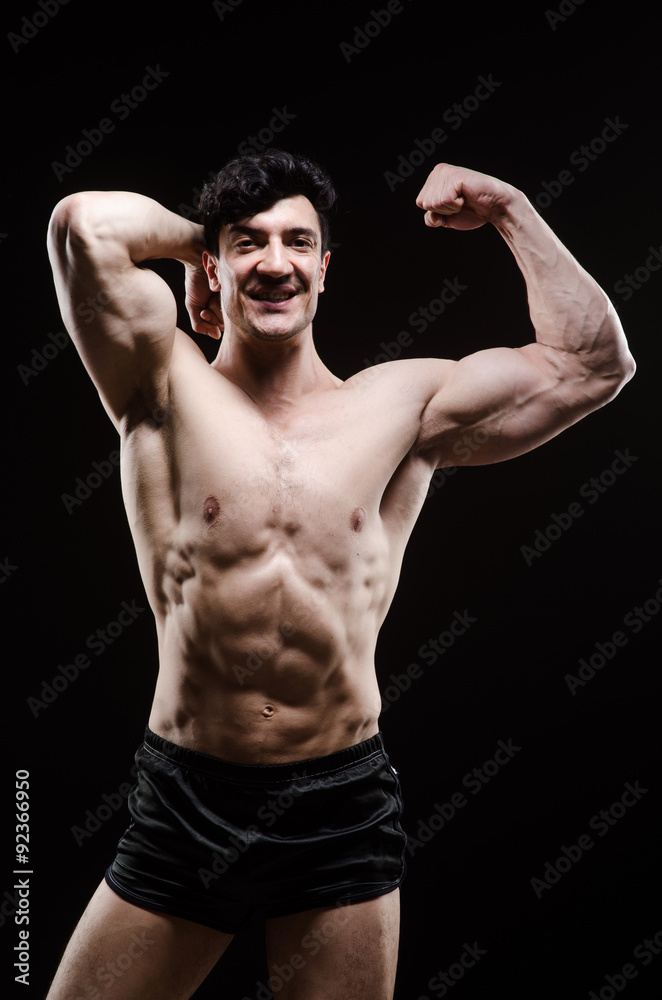 Fototapeta premium Muscular man posing in dark studio