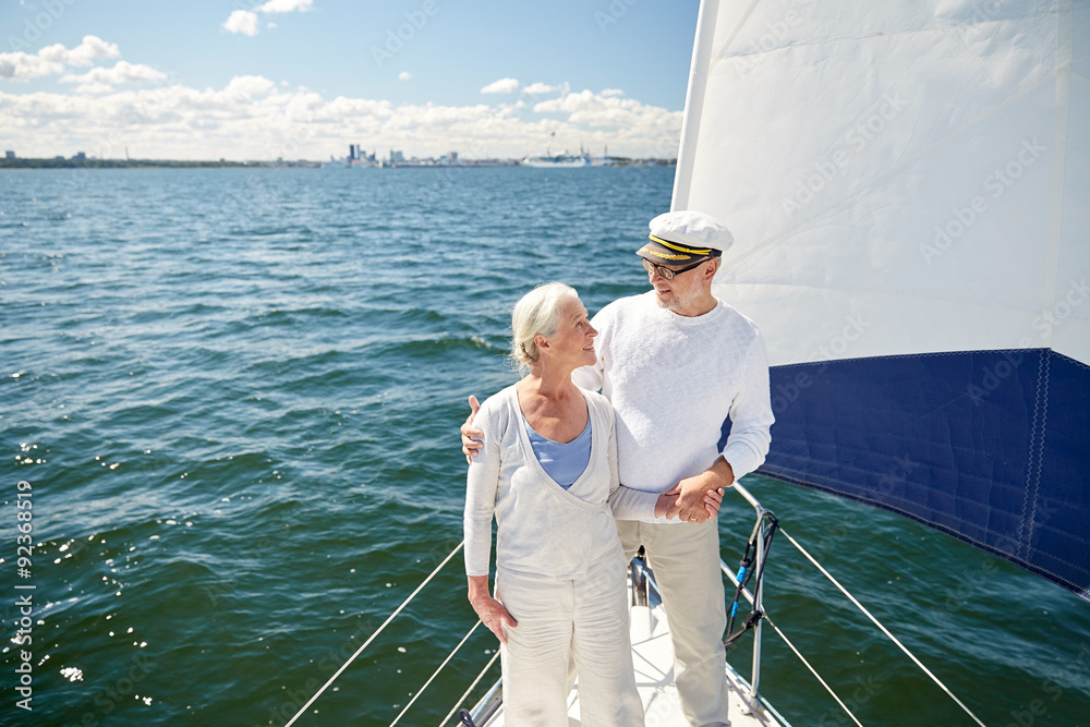Fototapeta premium senior couple hugging on sail boat or yacht in sea