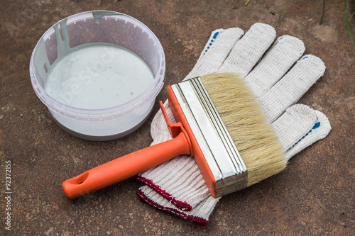 Paint, gloves, brush on rusty plate