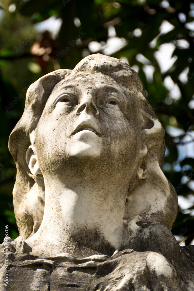 very old statue of a woman with a sorrow expression 