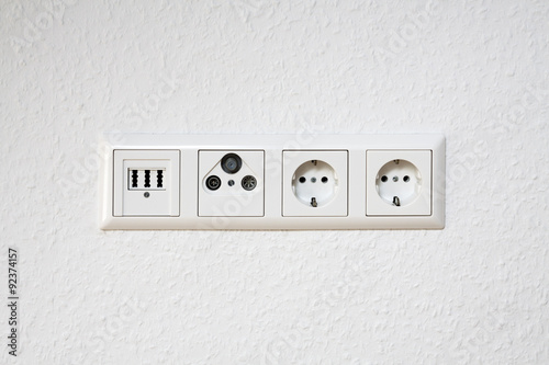 Electrical outlet, phone and antenna socket on room wall