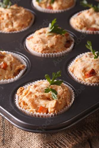 muffins with ham and cheese in baking dish close up. Vertical 