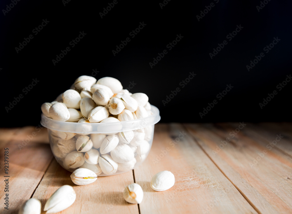Pistachio put in bowl and some on wood floor Pistachio put in bowl and some on wood floor