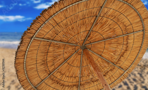 A reed sun umbrella symbolizing vacationing in summer