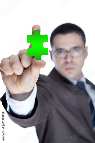 Businessman showing jigzaw puzzle piece photo