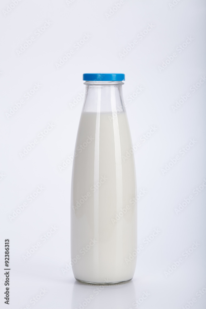 Glass milk bottle with blue cap on a white background Glass milk bottle with blue cap on a white background