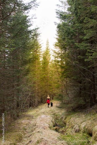 Girl walking her dog in the forest
