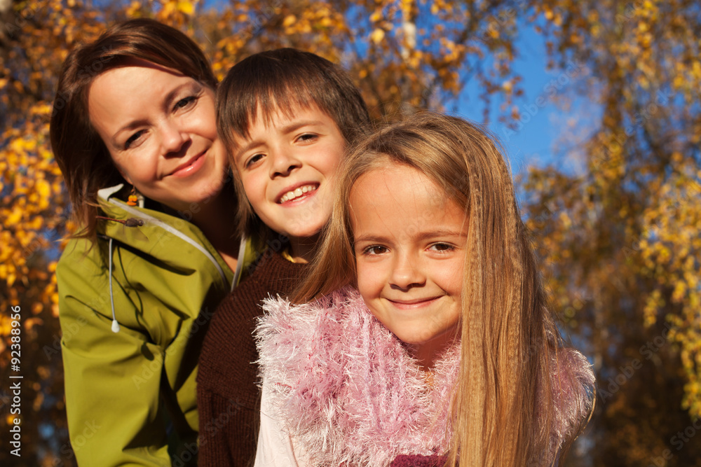 Fototapeta premium Autumn family portrait in the sunny forest
