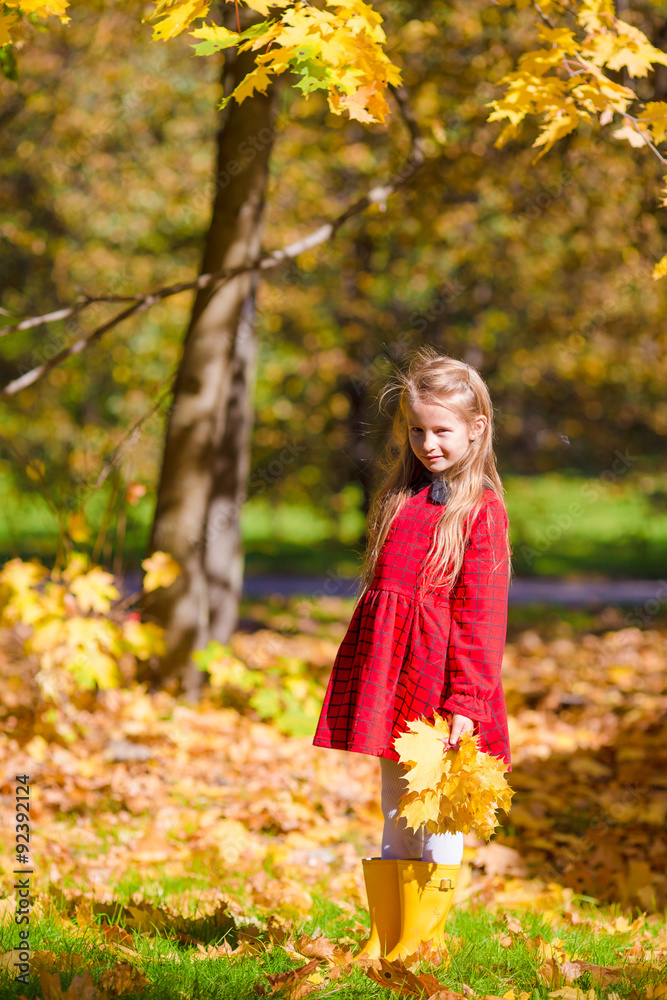 Adorable little girl with yellow maple leaves outdoors at Adorable little girl with yellow maple leaves outdoors at
