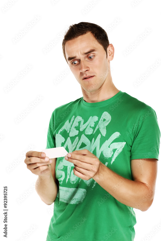 Young man holding a white card, wondering. Young man holding a white card, wondering.