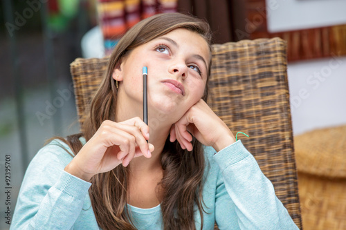 beautiful girl student doing her homework pensively