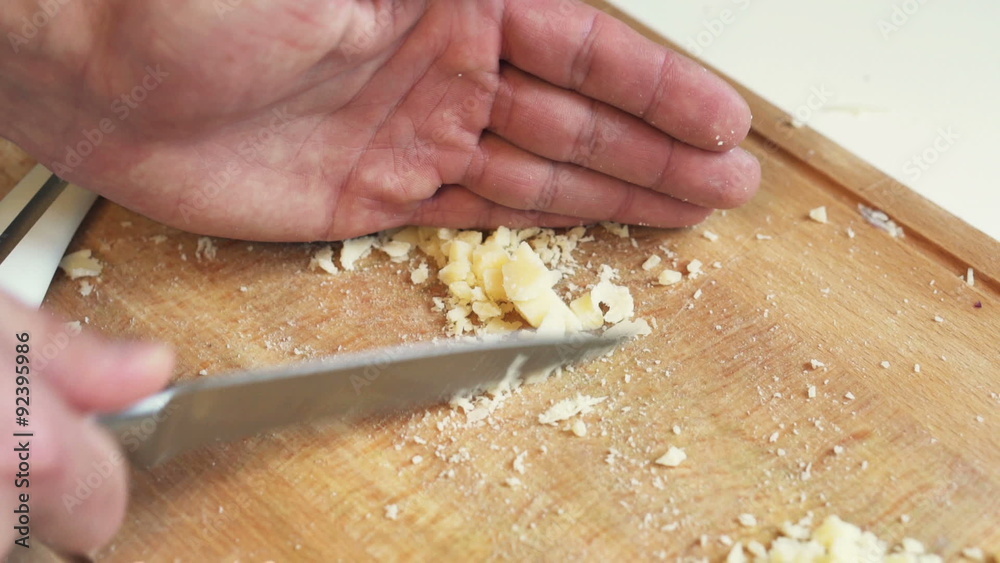 Man slicing cheese on table in kitchen
Man slicing cheese on table in kitchen
