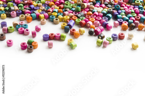 Colorful wooden beads scattered on white