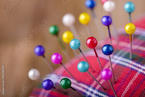macro colored sewing pins in scottish pincushion