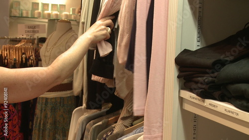 Shopper looking through clothes on a clothes rack photo