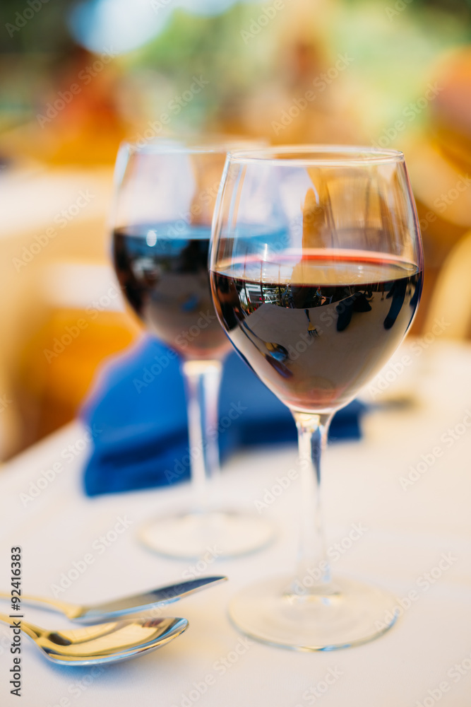 Two glasses of red wine are on table