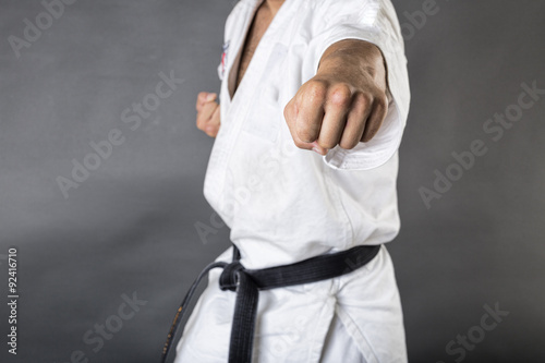 Young man in white kimono and black belt training martial art photo