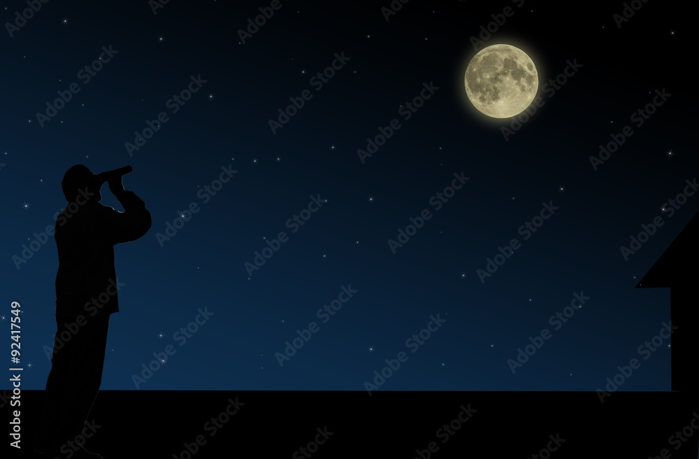 The man on the roof looks through binoculars at the full moon at night The man on the roof looks through binoculars at the full moon at night