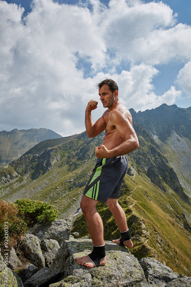Fototapeta premium Kickboxer or muay thai fighter training on a mountain