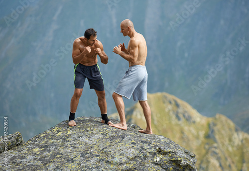 Kickboxers or muay thai fighters training on a mountain cliff