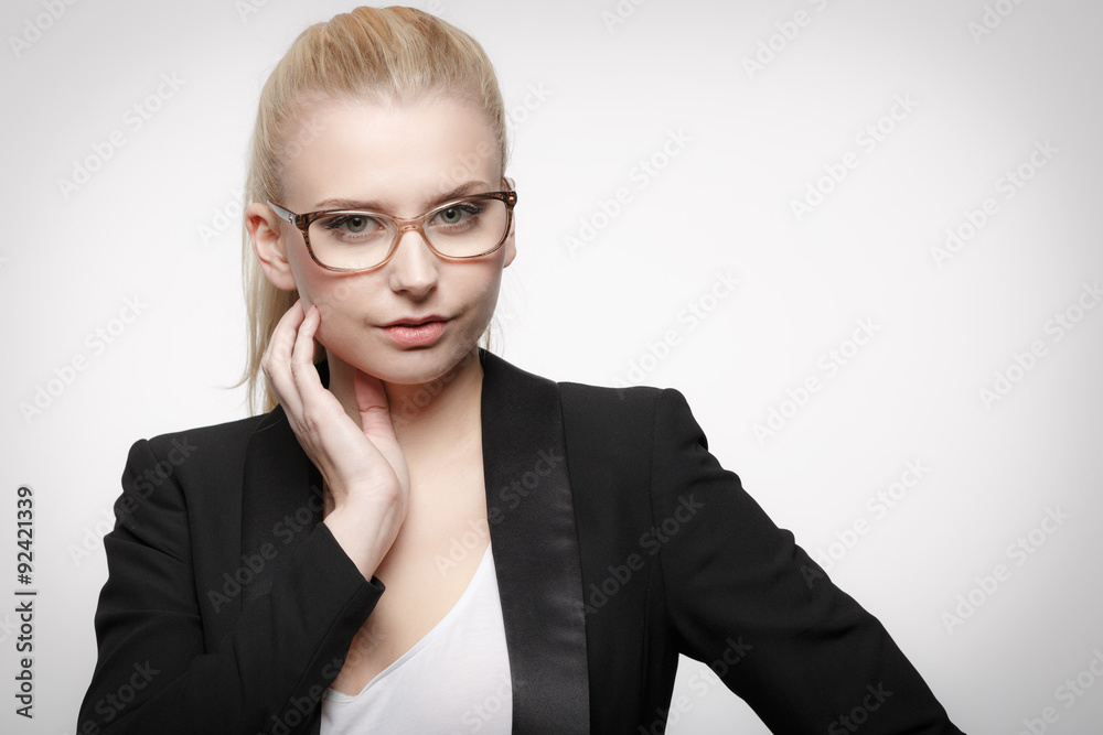 Junge hübsche blonde Mitarbeiterin im Blazer mit Lesebrille Junge hübsche blonde Mitarbeiterin im Blazer mit Lesebrille