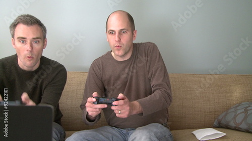 Two men playing a video game in the living room photo