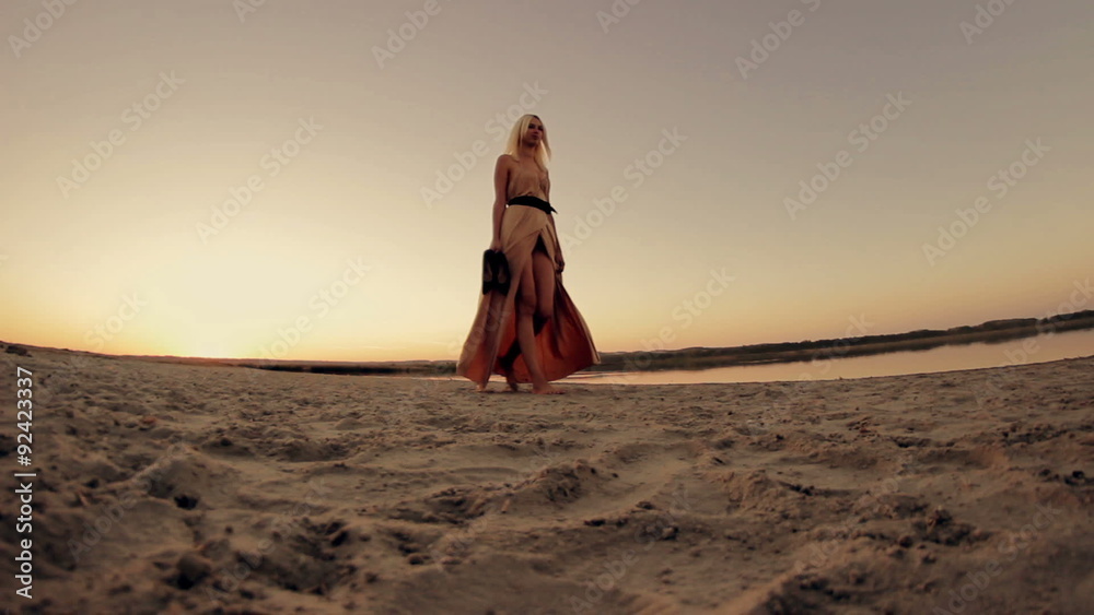 Sexy beautiful girl model in dress walking on the beach at Sexy beautiful girl model in dress walking on the beach at