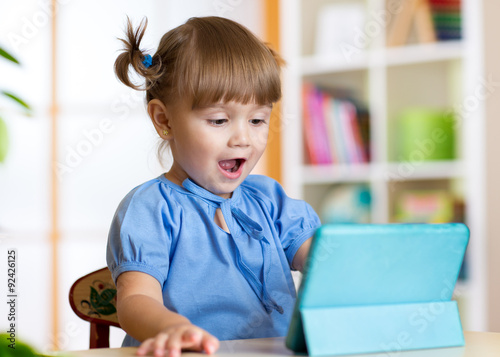 child playing with a digital tablet at home