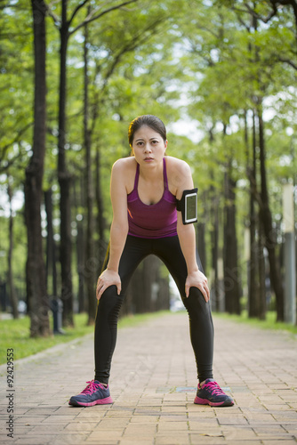 Asian young woman tired because jogging , cell phone