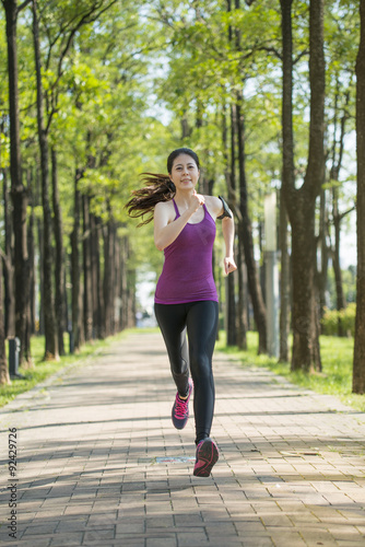 Asian young woman jogging in the forest, outdoors