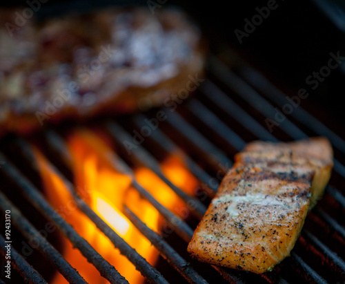 hot dogs, steaks and salmon on a grill