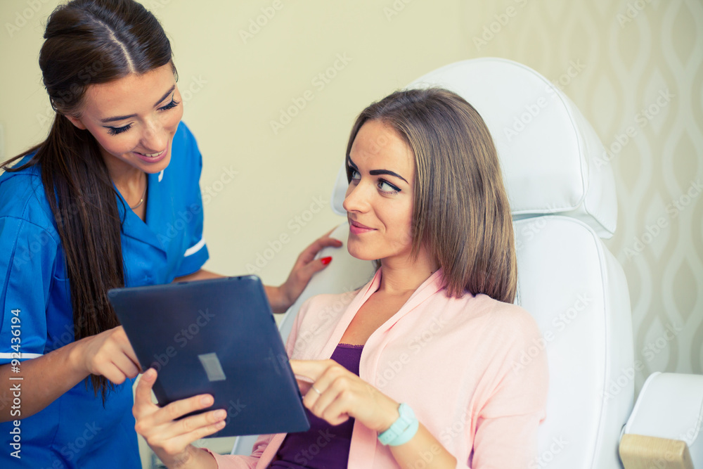 Beautiful woman showing hairstylist on a tablet examples hairstyles. Beautiful woman showing hairstylist on a tablet examples hairstyles.