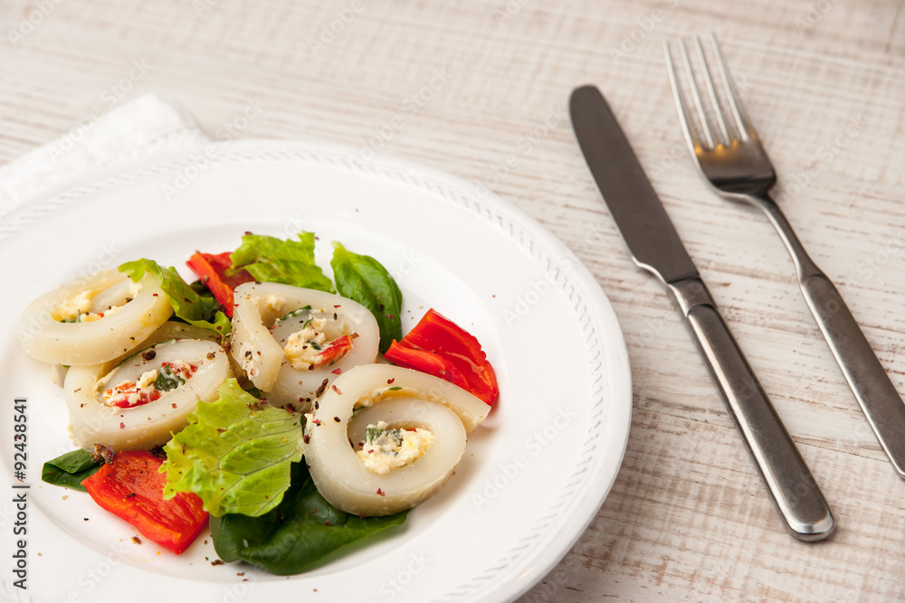 Squid roll with cheese and vegetables on the ceramic plate horizontal Squid roll with cheese and vegetables on the ceramic plate horizontal