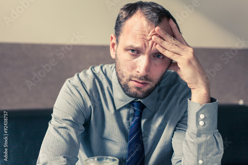 Stressed businessman getting a headache at home in the living room.