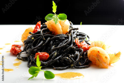 Vászonkép Fine dining, Italian squid ink pasta with shrimp basil selective focus