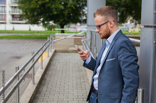 Wallpaper Mural Caucasian businessman outside office using mobile phone outside office building.  Torontodigital.ca