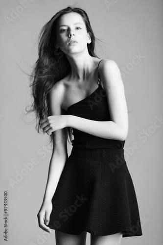beautiful young model in elegant black dress posing in the studi