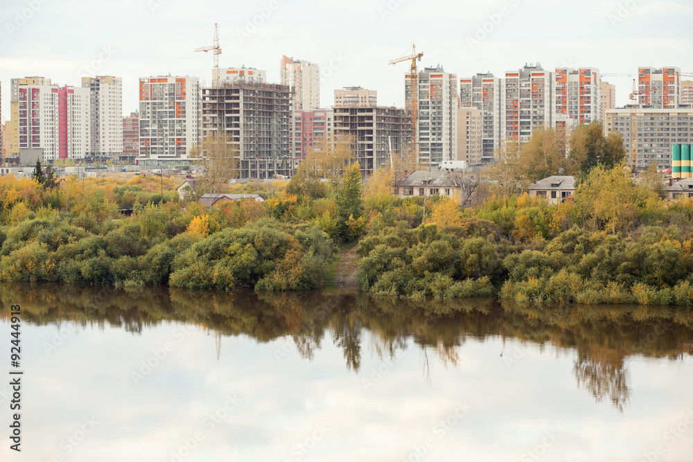 Residential apartments on a river bank in autumn