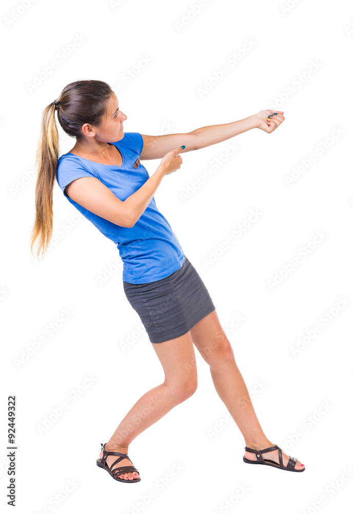 back view of standing girl pulling a rope from the top or cling back view of standing girl pulling a rope from the top or cling