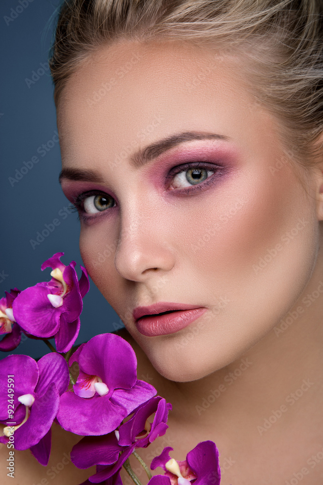 Close up portrait of blonde woman with orchid Close up portrait of blonde woman with orchid
