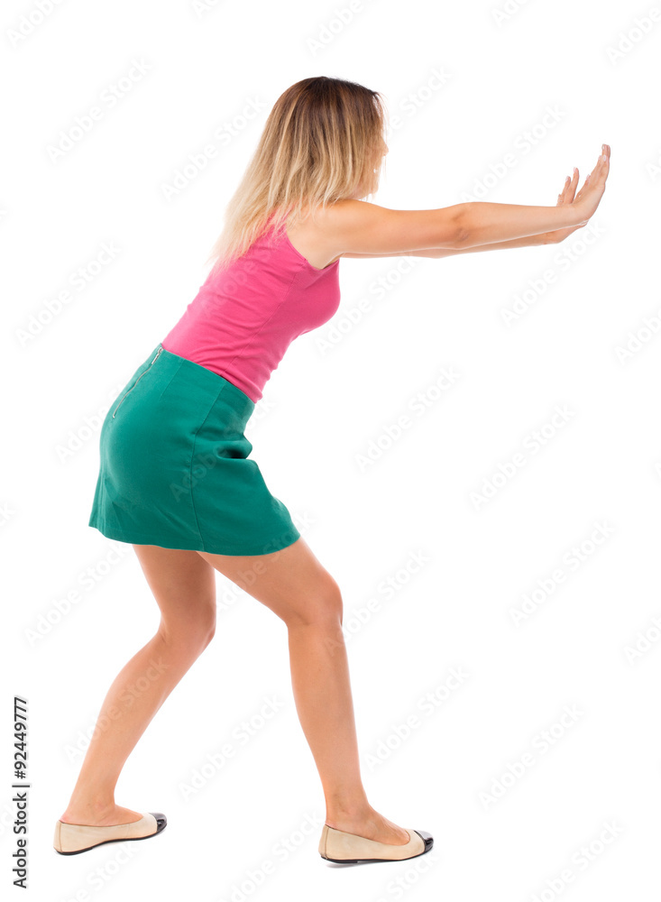 back view of woman pushes wall. back view of woman pushes wall.