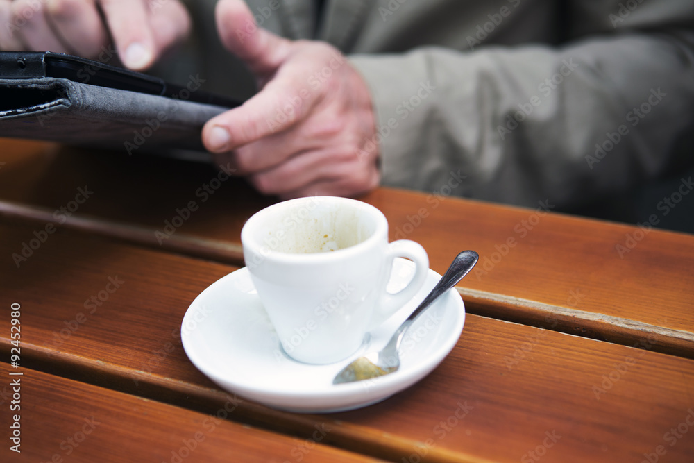 closeup of man holding a tablet and with cup of coffee closeup of man holding a tablet and with cup of coffee