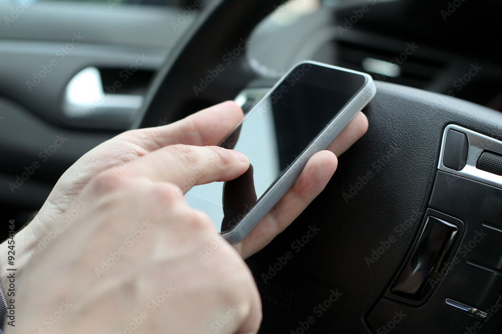 businwssman using mobile smart phone while driving the car businwssman using mobile smart phone while driving the car