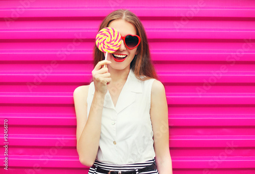 Sweet pretty young woman having fun with lollipop over pink back © rohappy