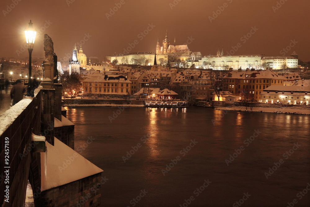Night romantic colorful snowy Prague gothic Castle with Charles Bridge, Czech Republic