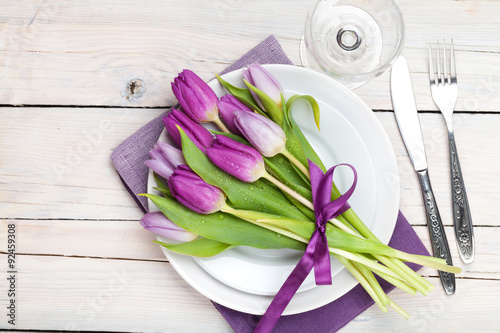 Fototapeta Naklejka Na Ścianę i Meble -  Purple tulip bouquet over plate on wooden table
