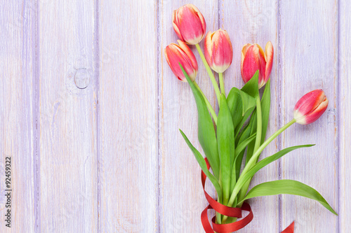 Fototapeta Naklejka Na Ścianę i Meble -  Red tulips over purple wooden table